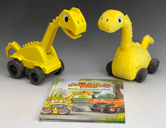 The yellow Brontie Brontosaurus excavator construction toy is show here as a molded plastic toy and his plush toy version. The plush toy is soft and cuddly and perfect for ages 2 and up. The two toys are looking down onto there Prehistoric Pals-Brontie and pals Build a Park Book. Brontie loves to work together with his friends to make and build the world a better place. 